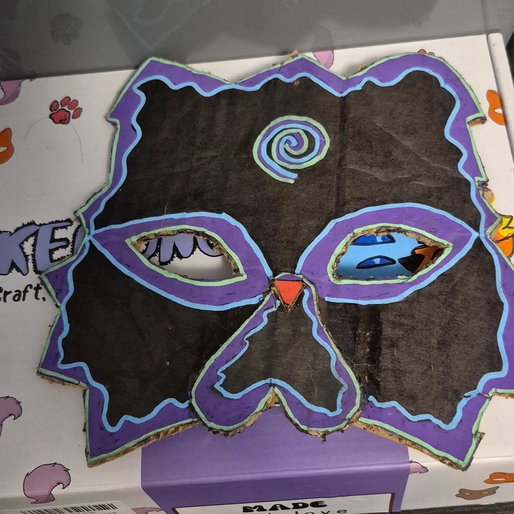 Black Therian mask with purple, blue, and green designs